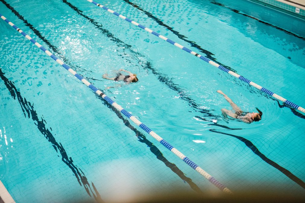 Kaksi naista ui selkää Yrjönkadun uimahallissa. Kuva: Helsingin kaupunki / Jussi Hellsten