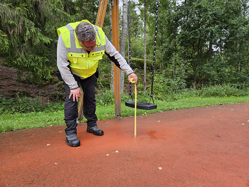 Staran leikkivälinetarkastaja Lars-Peter Bäckström mittasi maavaraa Intian leikkipuistossa.