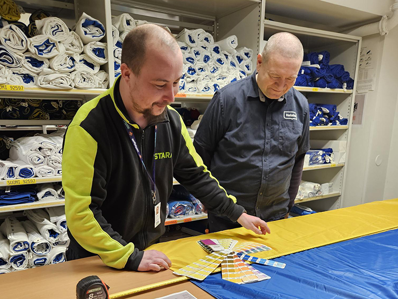 Staran Henri Virtanen ja Raimo Öster tarkastavat, että lipputehtaalta tulleen Ukrainan lipun värit ovat oikeanlaiset.