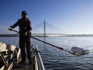 Staran meri- ja saaristopalveluiden työntekijä Lippo-aluksella nostamassa roskaa merestä.